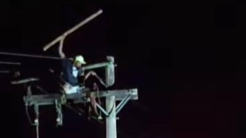 Homem sobe em poste de luz para fugir da PM